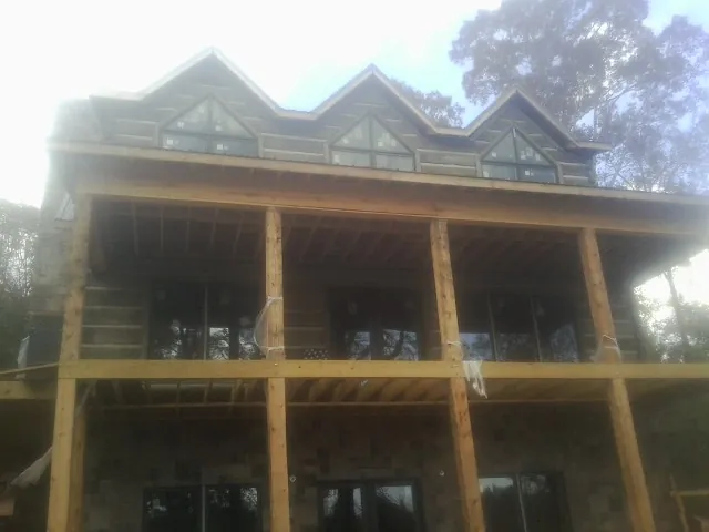 Dormers and porch framing on a large log home under construction — Roof Coating work by our crew in Redwood