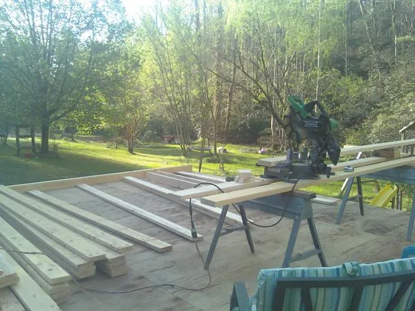 Miter saw and framing lumber on a deck under construction in Redwood