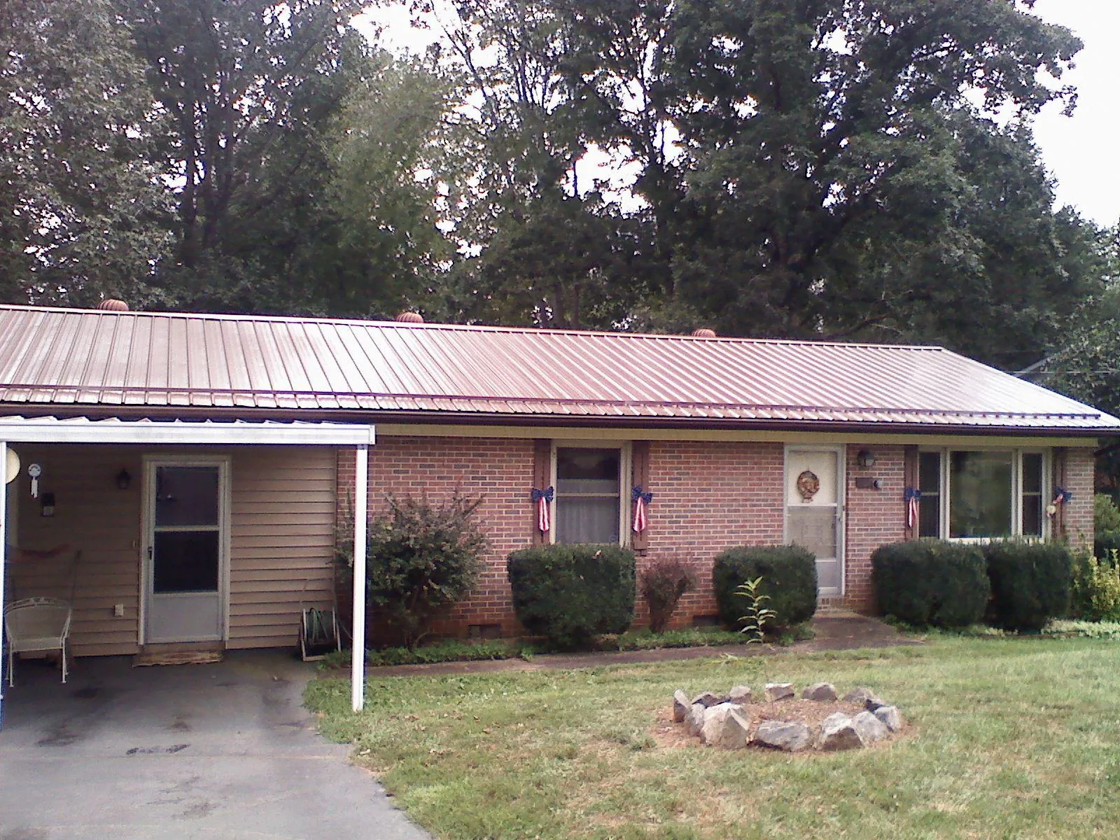 Bronze metal roof and carport on a brick ranch home — Roof Repair work by our crew in Redwood